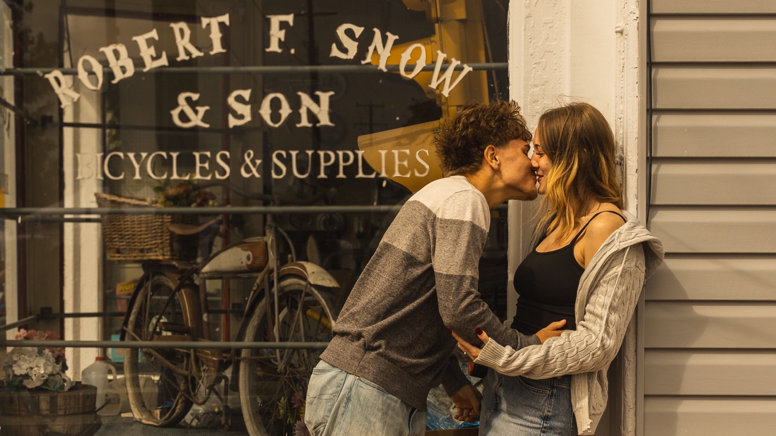 A kiss outside the little bicycle shop.